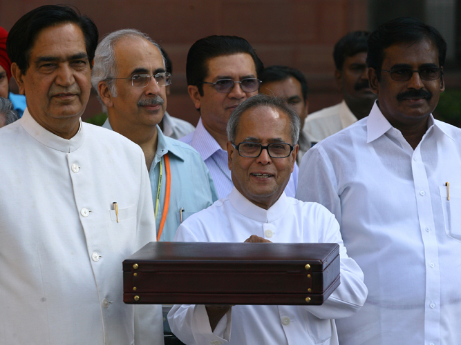 India's Finance Minister Pranab Mukherjee smiles as he leaves his office to present the 2009/10 federal budget in New Delhi July 6, 2009.