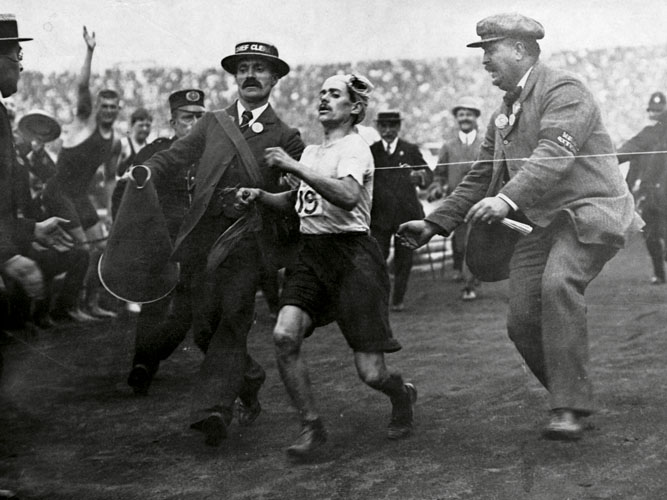 RACE OF A LIFETIME: Race of a Lifetime A racing clerk assists the Italian runner Dorando Pietri across
the finish line in the 1908 London Olympics marathon. Pietri was first past the post after taking a wrong turning and receiving medical attention for a fall. Although disqualified, he received a gold cup for his efforts from Queen Alexandra